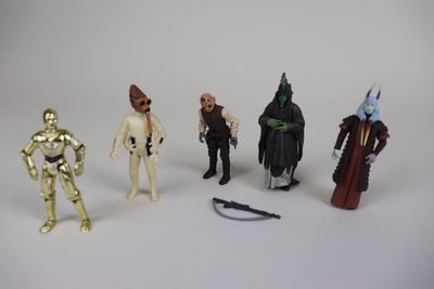 cinq figurines de Star Wars posées sur une surface blanche