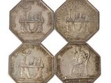 four silver coins of different sizes and shapes on a white background