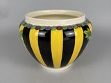 black and yellow striped vase with flowers on the rim