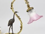 une lampe sur laquelle est représenté un oiseau à côté d'une fleur