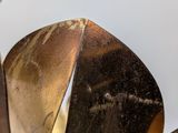 a close up of a metal object with a white background
