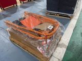 un chariot sur lequel est posé un parapluie rouge, dans un entrepôt