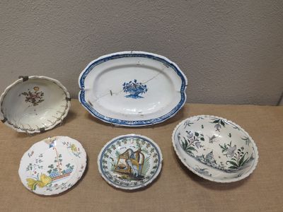 cinq assiettes et un bol posés sur une table