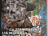 peinture représentant le visage d'un homme sur un mur, avec en arrière-plan une autre peinture représentant le visage d'un homme