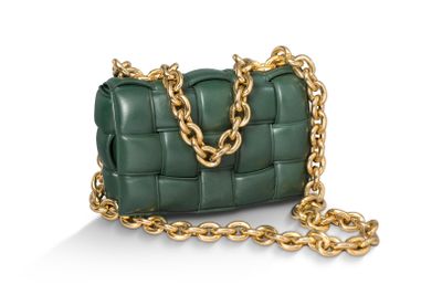 un sac à main en cuir vert orné de chaînes dorées sur fond blanc