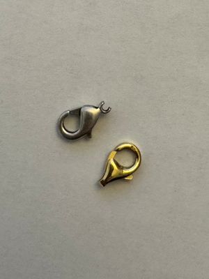 two pieces of silver and gold metal on a white surface