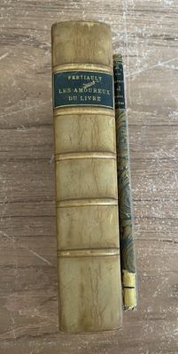 un vieux livre posé sur une table en bois, à côté d'un stylo