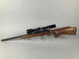 a rifle with a scope on a stand