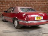 a red car that is parked in front of a brick wall