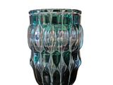 un vase en verre posé sur une surface blanche