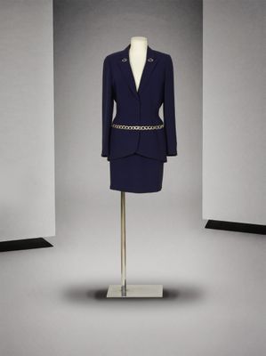 Cette image peut représenter un mannequin et un costume posé sur un support pour mannequin.