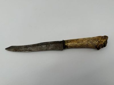 un couteau avec un manche en bois sur une surface blanche