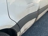 une voiture blanche avec une bande noire, garée sur le bord de la route