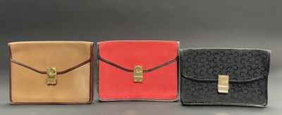 three different colors of purses are lined up on a table