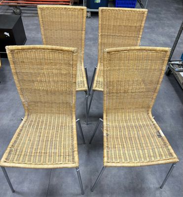 quatre chaises en osier à pieds métalliques dans un décor d'entrepôt