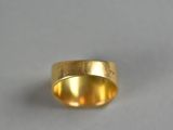 a close up of a gold ring on a white surface