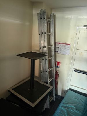 a small room with a ladder and a bed in it
