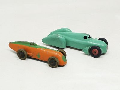 deux voitures jouets assises l'une à côté de l'autre sur une surface blanche