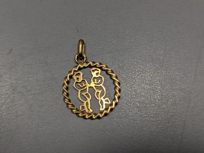 un pendentif plaqué or représentant un homme et une femme à l'intérieur d'un cercle