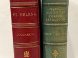 trois livres sont empilés sur une surface blanche