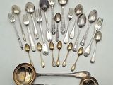 a lot of silver spoons and spoons on the table