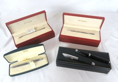 trois stylos et un stylo dans une boîte posée sur une surface blanche