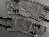 deux paires de chaussures en tissu gris avec des lanières en cuir noir, posées sur un fond gris