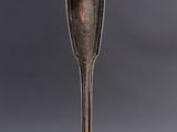 an old spoon with a spoon handle sitting on top of a table