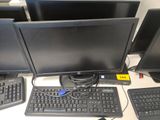 trois écrans d'ordinateur et un clavier posés sur un bureau