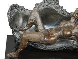 a bronze sculpture of a woman laying on a shell