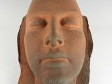 une sculpture en argile représentant le visage d'une femme sur un fond blanc