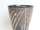 a close up of a cup on a white surface