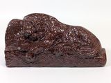 chocolate figurine of a dog laying down on a white surface
