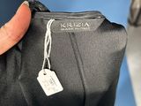 the person is holding a black jacket with a tag on it