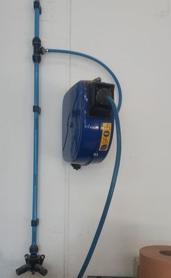 un tuyau bleu fixé au mur à côté des toilettes