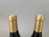 two bottles of wine sitting next to each other on a table