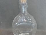 a clear glass bottle with a gold lid