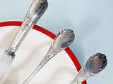 three spoons and a fork in a red and white bowl