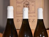 three bottles of wine sitting on a table next to a box