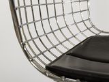the chair is made of metal and has a black cushion