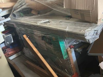une pile de cartons posée sur un bureau dans une pièce encombrée