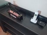 une table sur laquelle se trouvent un téléphone portable et un chargeur