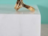 an image of a gold ring sitting on top of a white marble block