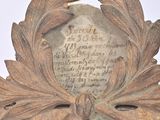 a plaque on the top of a table with a leaf decoration