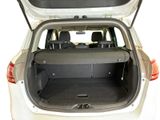 the back of a white car with its trunk open and the back seats down