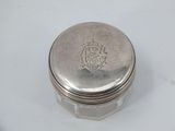 an old silver box with a silver lid sitting on a white surface