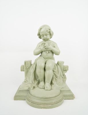 a small statue of a child sitting on a bench
