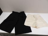 two pairs of black and white shorts sitting on a white table