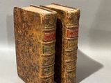 deux vieux livres posés l'un sur l'autre sur une table