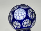 a blue glass ball with white dots on it